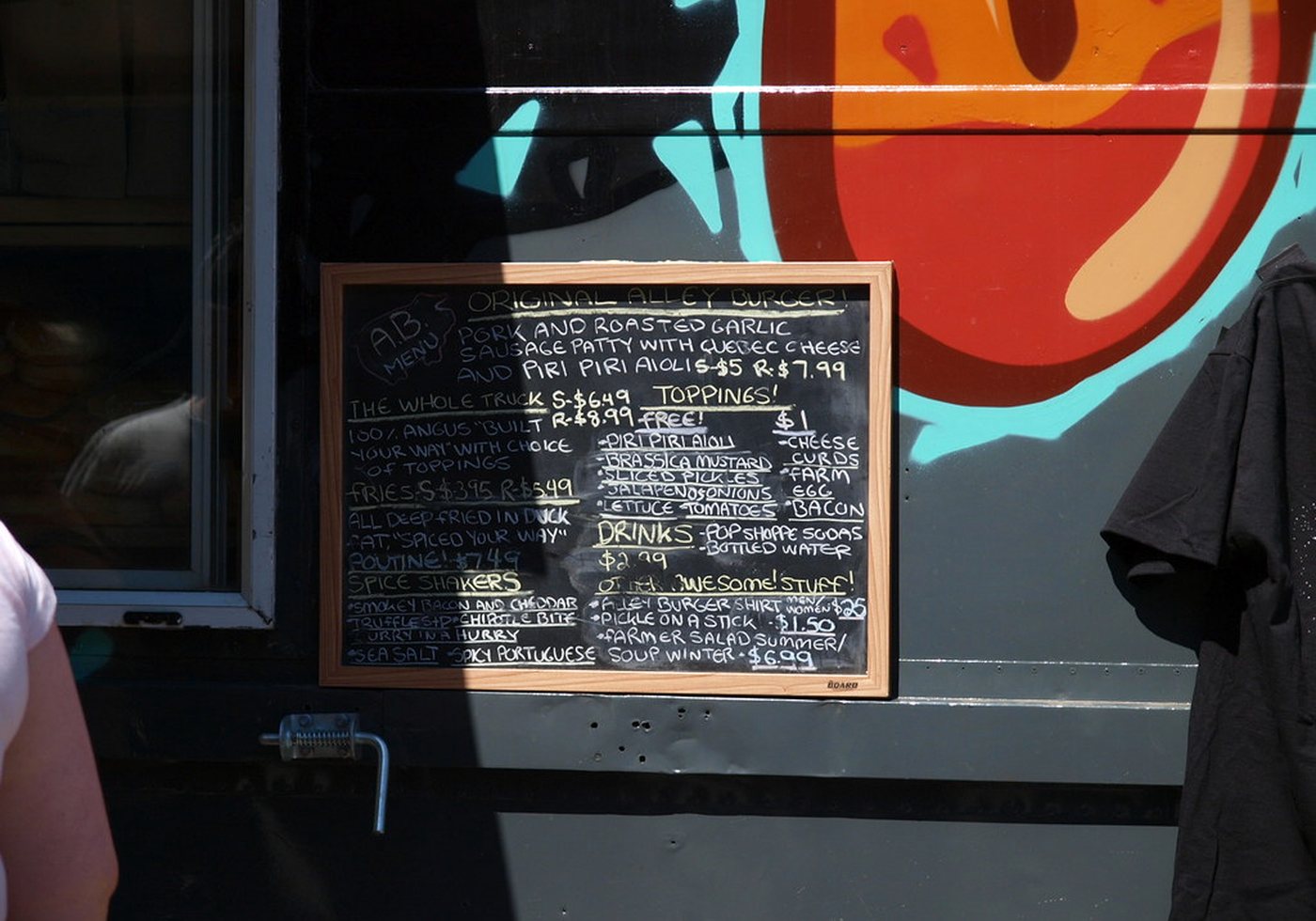 Burger menu board photographed beside an outdoor ordering counter