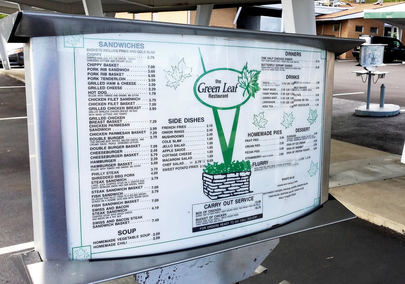 Large drive-in restaurant menu board with item lists and pricing