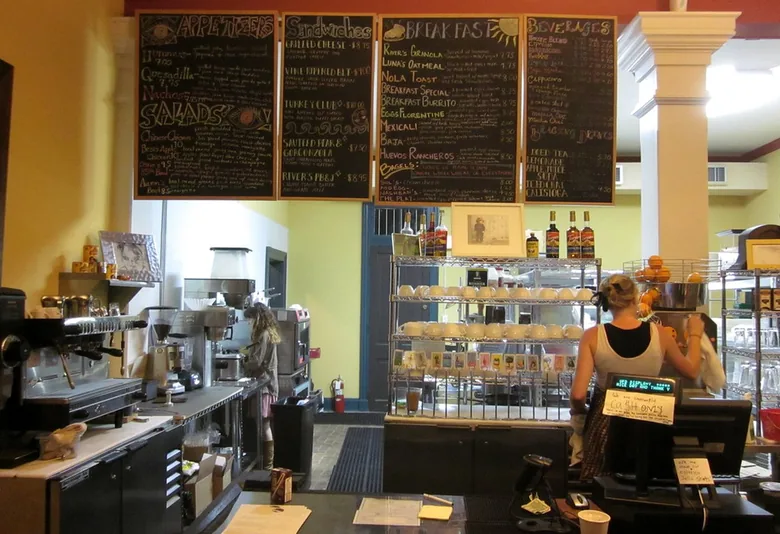 Cafe counter with large blackboard menu panels above the barista station