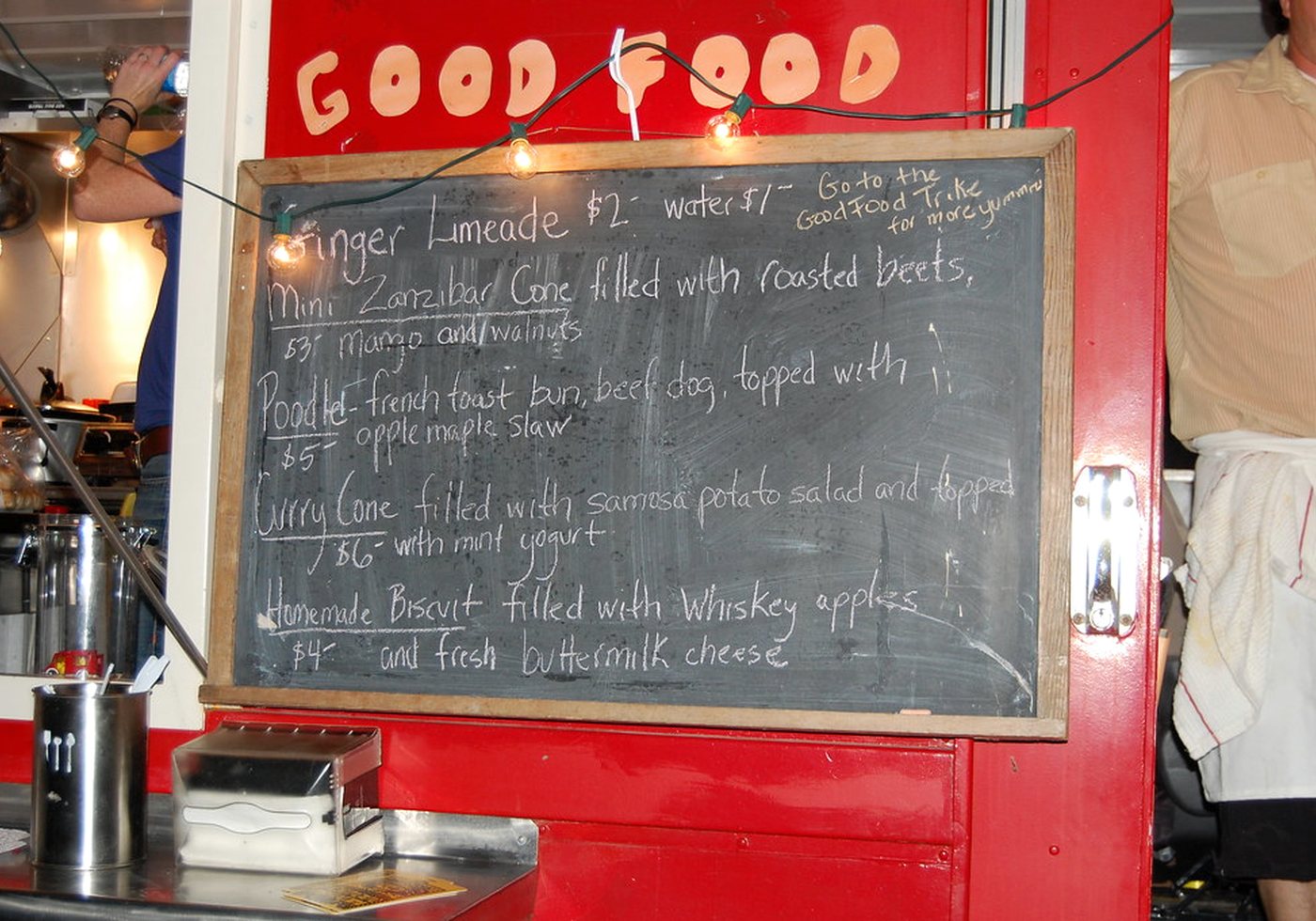 Takeaway menu board beside a food truck ordering window